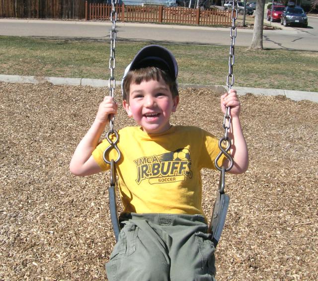 Elijah happy on a swing